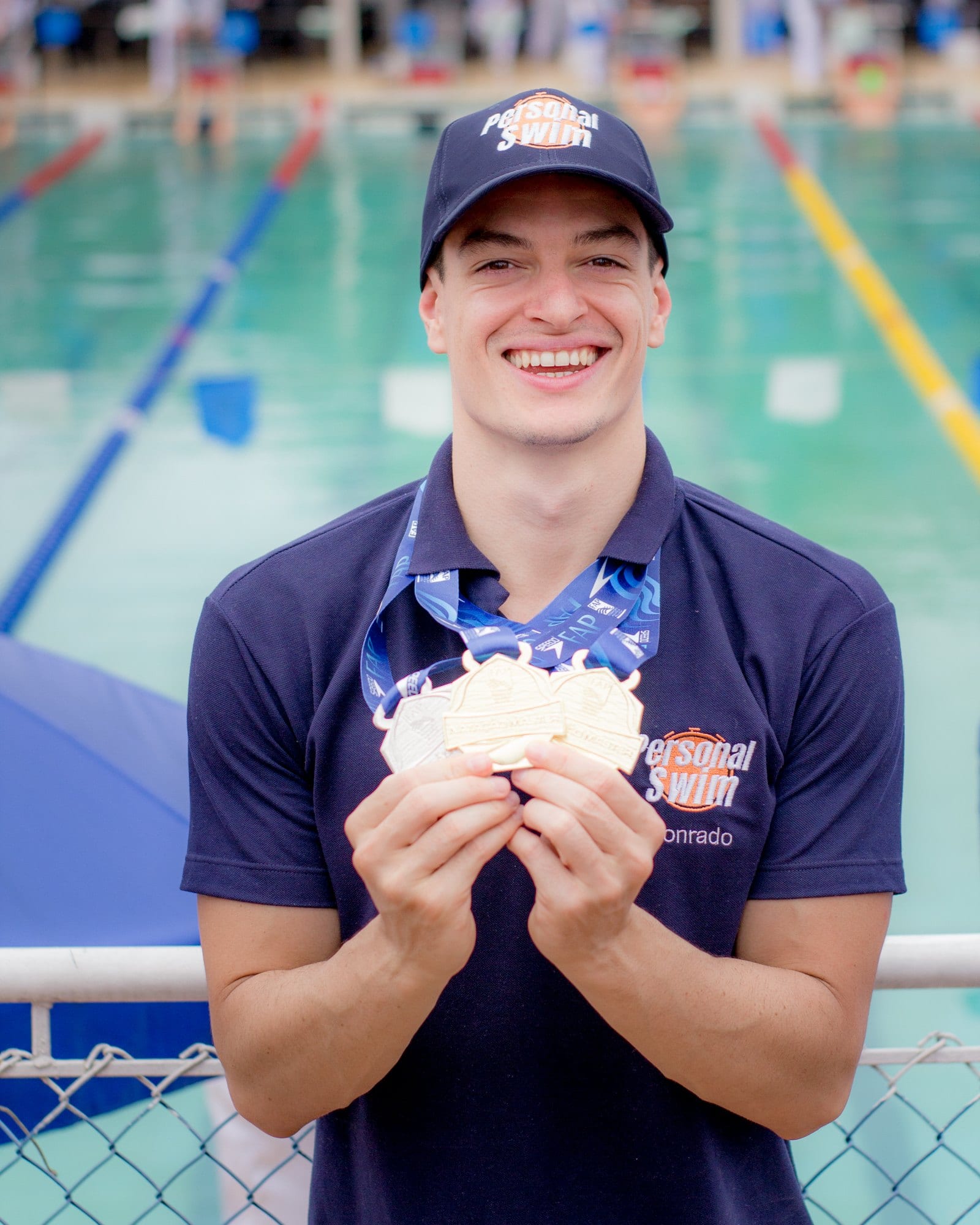 Conrado Lino com medalhas na beira da piscina
